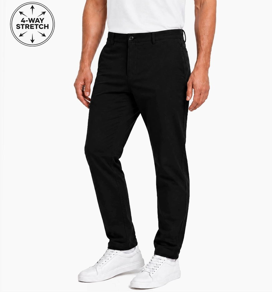 A man wearing black slim-fit pants and white sneakers, shown from the waist down on a light gray studio background. A circular '4-WAY STRETCH' badge appears in the top-left corner.