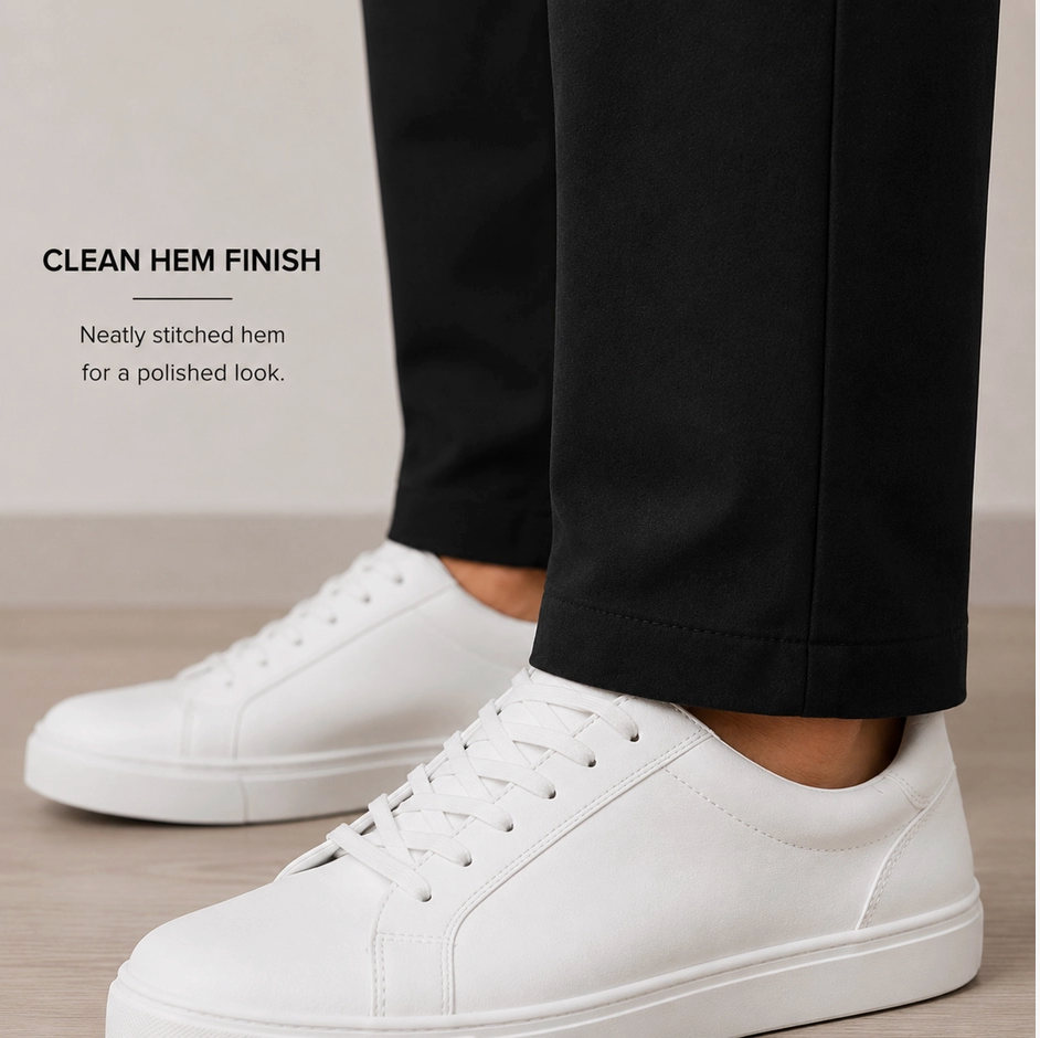 White leather low-top sneakers worn with black trousers, shown from the side with text on the left reading 'CLEAN HEM FINISH' and 'Neatly stitched hem for a polished look.'.